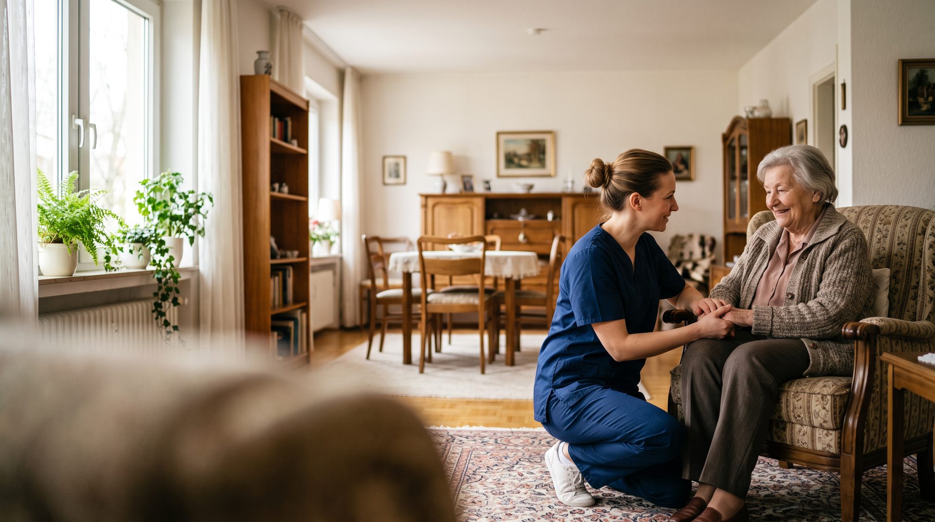 Pflegekraft hält die Hand einer Seniorin im Wohnzimmer – häusliche Pflege von MediCare in Offenbach